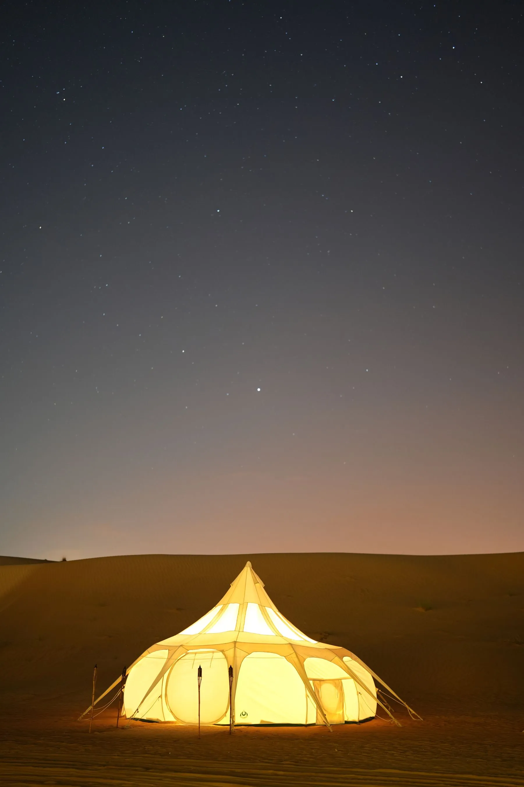Carpa iluminada al atardecer en el desierto